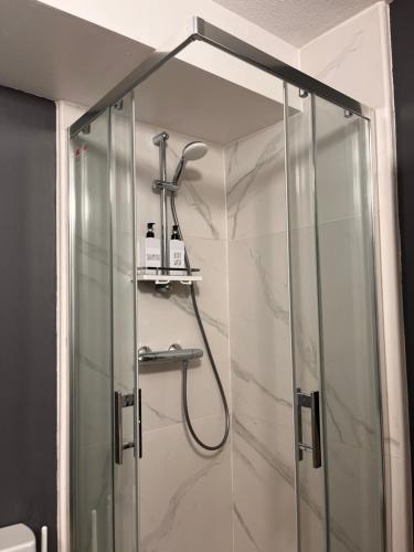 une douche avec une porte vitrée dans une salle de bain dans l'établissement Studio côté plage tout équipé vue sur le Canigou, à Canet