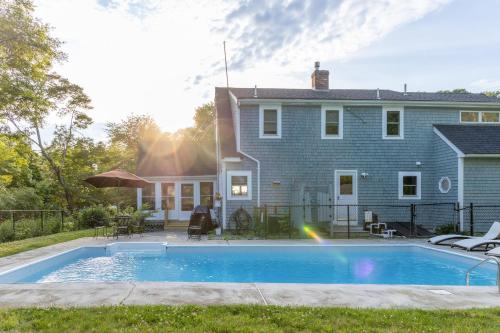 a swimming pool in front of a house at Private Pool and Screened Deck Mashpee Home! in Mashpee