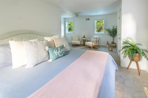 a bedroom with a large bed with a pink and blue blanket at Private Pool and Screened Deck Mashpee Home! in Mashpee