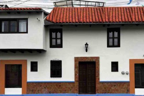 a white house with an orange roof at Casa 23 San Cristóbal in San Cristóbal de Las Casas
