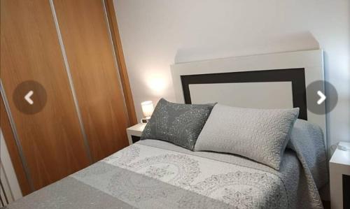 a small bedroom with a bed and a wooden door at Apartamento El Ancla in Almería