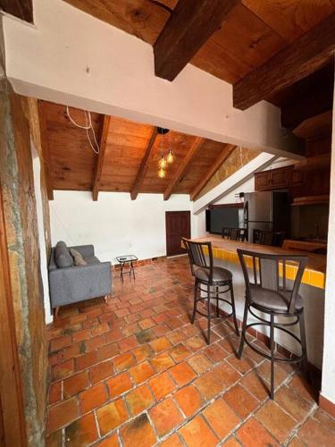 a living room with chairs and a table and a kitchen at Casa 23 San Cristóbal in San Cristóbal de Las Casas