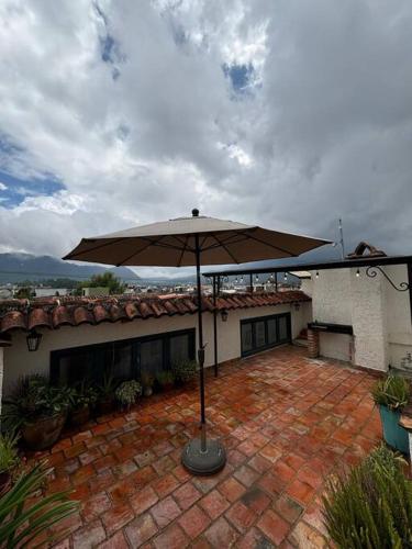 a patio with an umbrella in front of a house at Casa 23 San Cristóbal in San Cristóbal de Las Casas