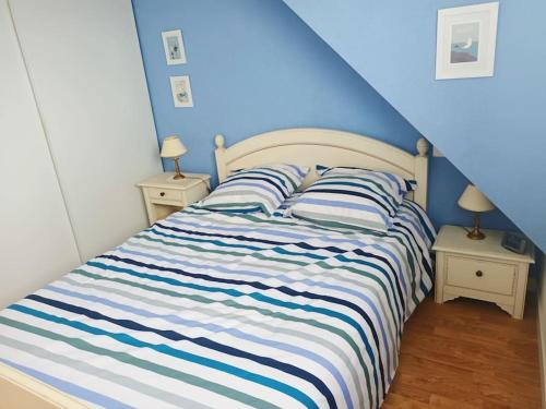 - une chambre bleue avec un lit à rayures bleues et blanches dans l'établissement St-Marc T3 face mer à 20m de la plage, à Saint-Nazaire