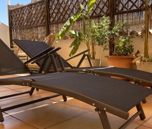 a row of lounge chairs on a balcony at Penthouse with amazing terrace and Altea sea views in Altea
