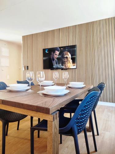 uma mesa de jantar com cadeiras e uma televisão na parede em Casa Náutica T2 em Ovar