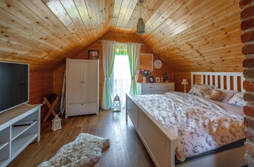 a bedroom with a large bed and a wooden ceiling at Kuća za odmor Vida in Čazma