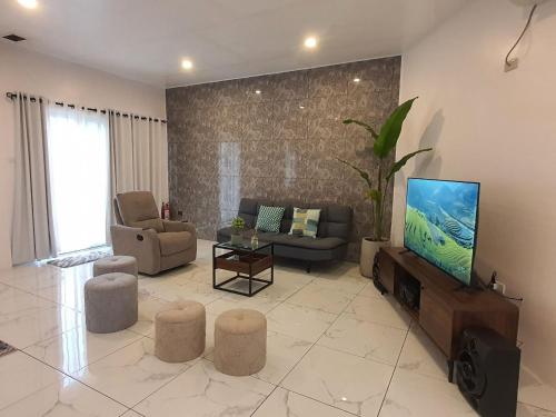 a living room with a television and a couch and chairs at MW UrbanTerrace -Surigao del Norte in Surigao