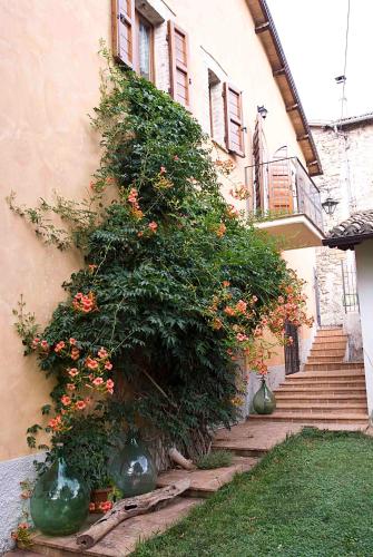 a building with a large bush with orange flowers at Casale del Monsignore in Spoleto