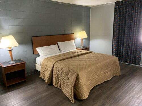 a bedroom with a large bed and two lamps at Paradise Suites - Newport News & Jefferson Ave in Newport News