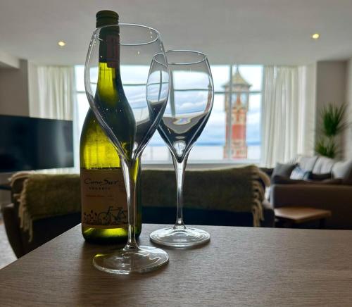 a bottle of wine and two glasses on a table at Clock Tower Apartments 1 in Morecambe