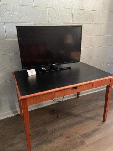 a television sitting on top of a wooden table at Paradise Suites - Newport News & Jefferson Ave in Newport News