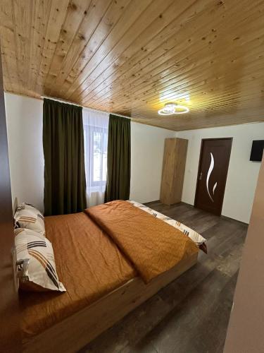 a bedroom with a bed in a room with wooden ceilings at Cabana Matei in Coasta Leşului