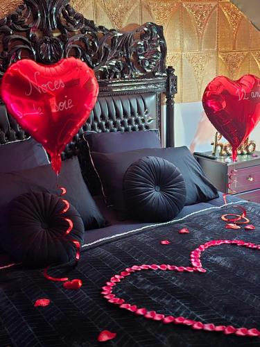 a bed with two hearts on the bed with red pedals at Maison équipée avec petit déjeuner gratuit - balnéo- sauna - siège massant et pièce secrète in Brachy