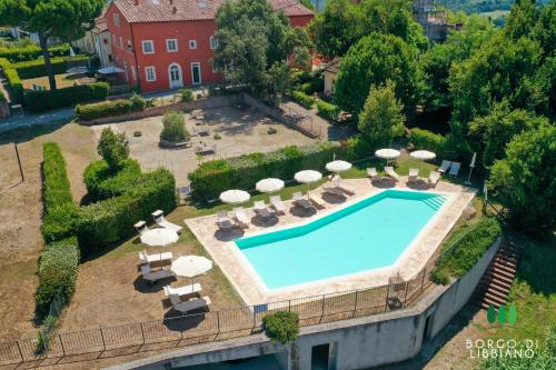 an overhead view of a swimming pool with umbrellas at Borgo di Libbiano - for exploring all of Tuscany in Libbiano