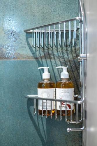 two bottles of soap on a rack in a bathroom at The Meta Stay - Rooftop Access Central Studio in Athens