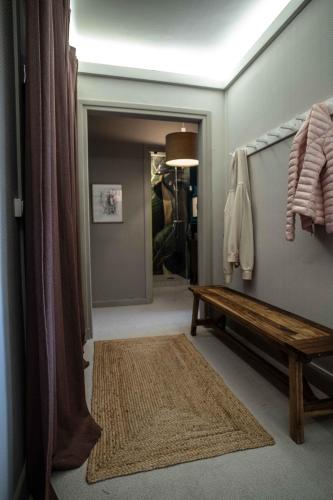 un couloir avec un banc, un miroir et une porte dans l'établissement Appartement cosy vue mer face NAUSICA, à Boulogne-sur-Mer