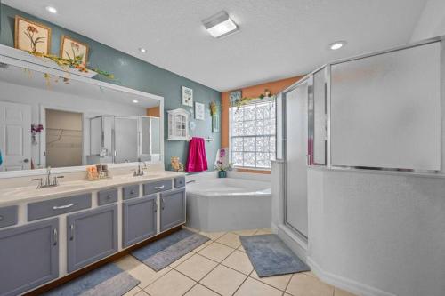 ein Badezimmer mit Badewanne und Waschbecken in der Unterkunft Mediterranean Garden Oasis in Davenport