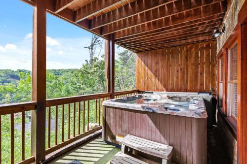 a large screened in porch with a hot tub at Classy Bear Cabin in Gatlinburg