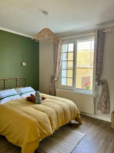 a bedroom with a yellow bed with a window at Maison la belle vue in Nogent-le-Rotrou