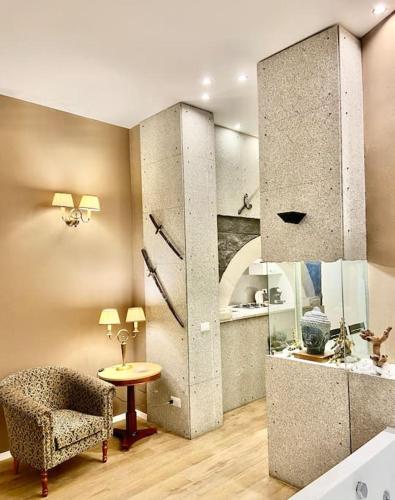 a room with a chair and a table in a room at Sebastian's Elegant Apartment in Aci Castello