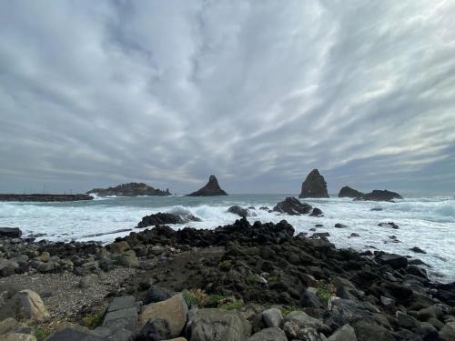 a rocky beach with rocks in the ocean at Sebastian's Elegant Apartment in Aci Castello