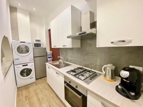 a kitchen with a stove and a washer and dryer at Sebastian's Elegant Apartment in Aci Castello