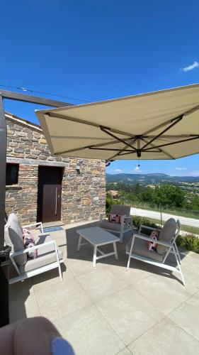 a patio with two chairs and an umbrella at Serre Alte Landscape Luxury Rooms in Matelica