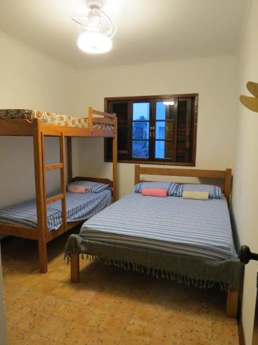 a bedroom with two bunk beds and a window at Bertioga Beach Hostel in Bertioga
