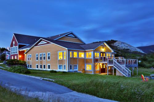 a large house with lights on in the evening at Neddies Harbour Inn in Norris Point