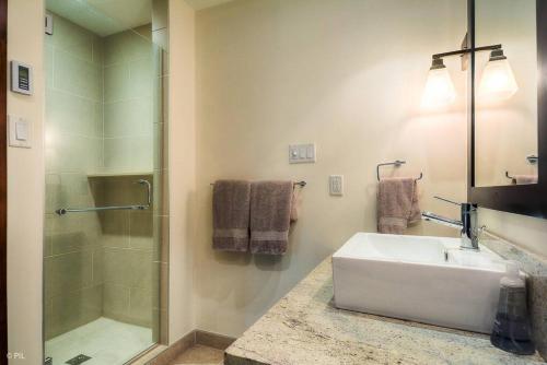 Un baño blanco con lavabo y ducha. en Étoile du Matin Tremblant Luxury Ski In Ski Out, en Mont-Tremblant