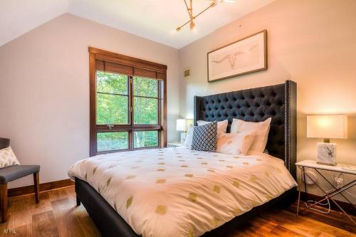 Un dormitorio con una cama grande y una ventana. en Étoile du Matin Tremblant Luxury Ski In Ski Out, en Mont-Tremblant