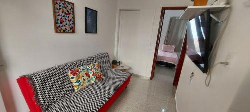 a living room with a couch with a pillow on it at SUH Copacabana 01 Nice Balcony Close To Beach in Rio de Janeiro