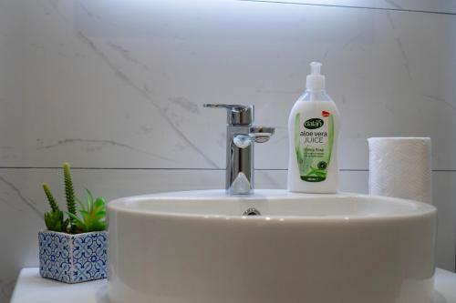 a bathroom sink with a bottle of mouthwash on it at Apartman Pike centar in Trebinje