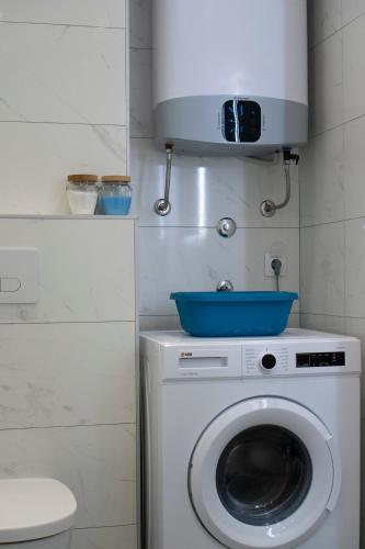 a washing machine with a blue bowl on top of it at Apartman Pike centar in Trebinje