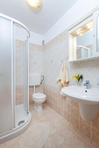 a bathroom with a shower toilet and a sink at Villa Lidija in Labin