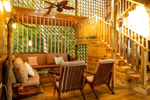 a living room with a couch and chairs in a cabin at Casa Cayuco Eco-Adventure Lodge in Bocas del Toro