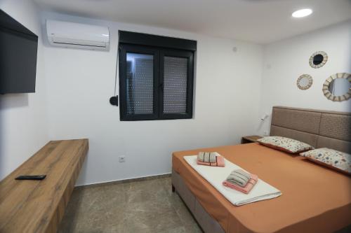 a bedroom with a bed and a wooden table at Magnolija apartmani in Igalo