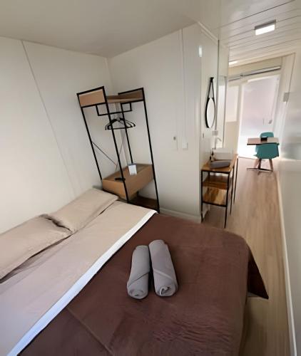 a bedroom with a bed with two white pillows on it at LN Studios in Uberlândia