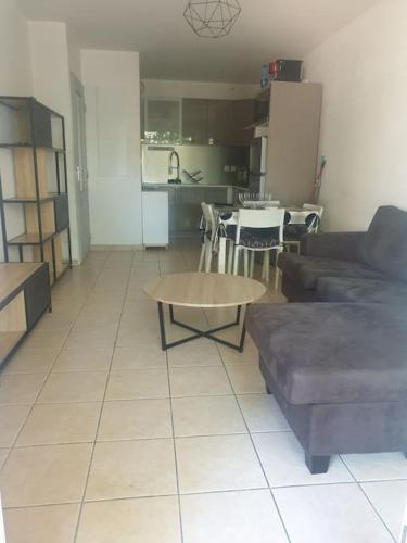 un salon avec un canapé et une table dans l'établissement T2 parking avec balcon, à Nîmes