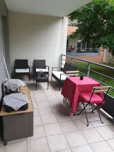 d'une terrasse avec une table et des chaises roses sur un balcon. dans l'établissement T2 parking avec balcon, à Nîmes