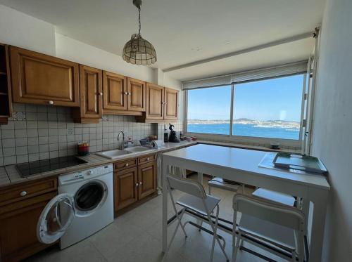 une cuisine avec un évier et une machine à laver dans l'établissement Panorama exceptionnel pour ce T4 en bord de mer, à Toulon