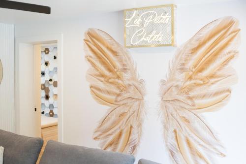 a pair of wings wall art on a living room wall at Les Petits Chalets in Val-des-Lacs