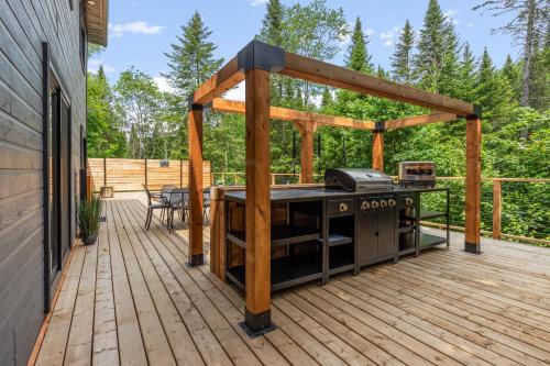 a patio with a grill on a wooden deck at Les Petits Chalets in Val-des-Lacs