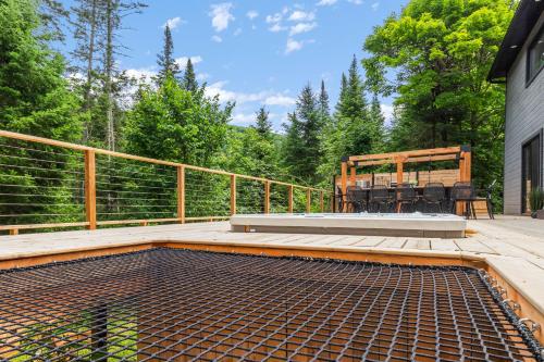 a patio with a table and a bench on a deck at Les Petits Chalets in Val-des-Lacs