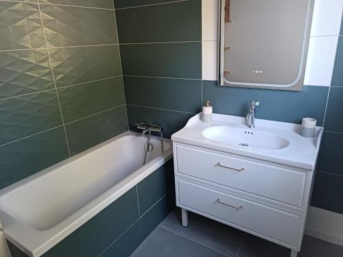 une salle de bain avec un lavabo blanc et une baignoire dans l'établissement La cabane, à Palaiseau
