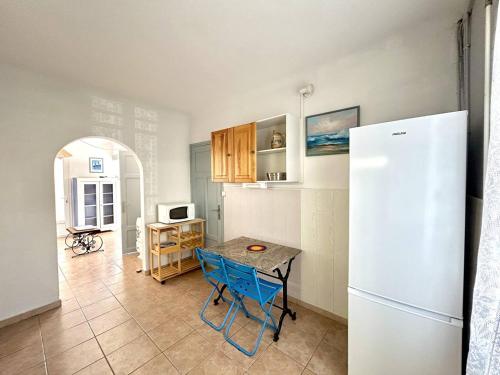 une cuisine avec une table et un réfrigérateur dans l'établissement Agréable maison de village à deux pas de la plage 4GSA12, au Barcarès