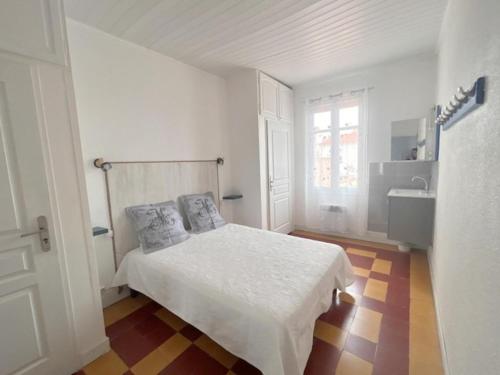 - une chambre blanche avec un lit et un lavabo dans l'établissement Agréable maison de village à deux pas de la plage 4GSA12, au Barcarès