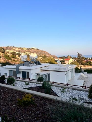 a white house with a telescope on top of it at Pissouri Image in Pissouri