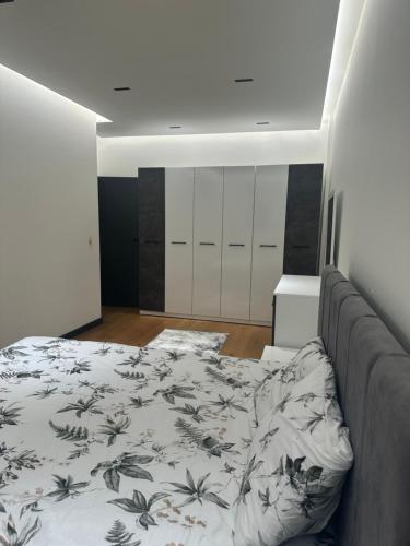 a bedroom with a bed with a floral blanket at Skyline Exclusive in Peje